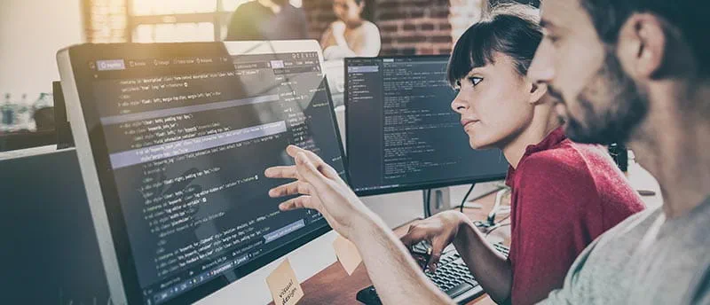 Frau und Mann arbeiten am PC - Informatiker:innen - DIS AG